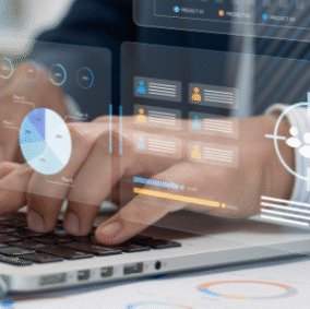 Hands typing on a laptop with overlay of towing program performance data dashboards