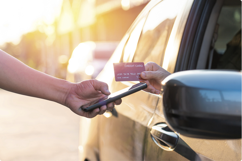 Driver paying for towing service on the roadside, passing credit card to provider through passenger door window